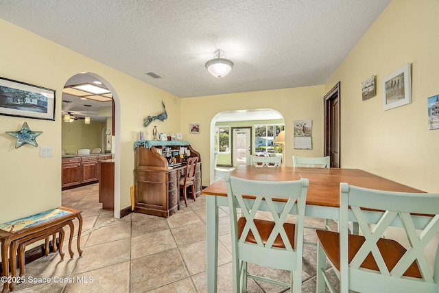 63 Yacht Haven Dr, Cocoa Beach, FL 32931 - dining area featuring arched walkways, a textured ceiling, and light tile patterned floors