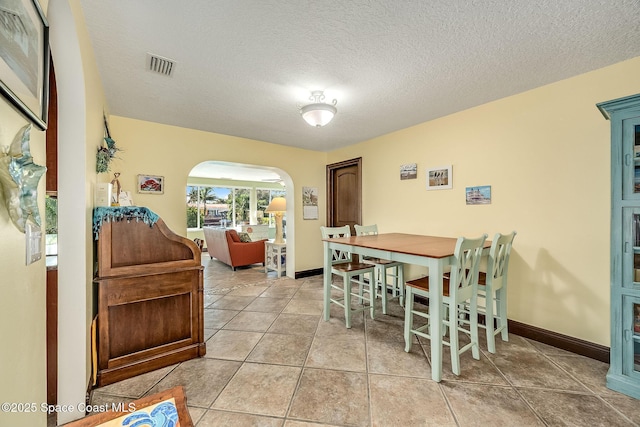 63 Yacht Haven Dr, Cocoa Beach, FL 32931 - dining room featuring arched walkways, a textured ceiling, and tile patterned floors
