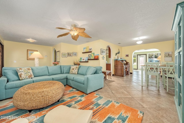 63 Yacht Haven Dr, Cocoa Beach, FL 32931 - living room with arched walkways, a textured ceiling, a ceiling fan, and light tile patterned floors