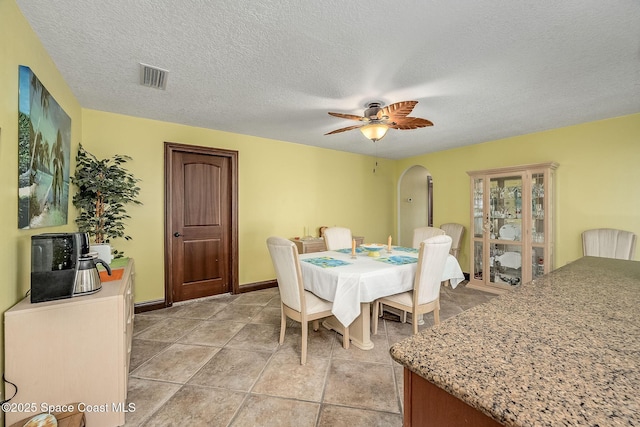 63 Yacht Haven Dr, Cocoa Beach, FL 32931 - dining space with arched walkways, a ceiling fan, and a textured ceiling