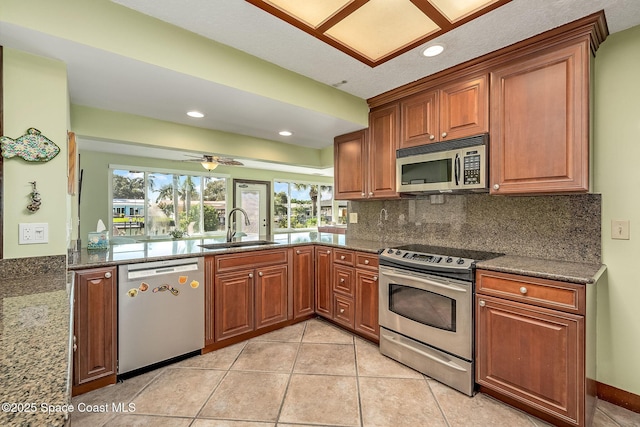 63 Yacht Haven Dr, Cocoa Beach, FL 32931 - kitchen with appliances with stainless steel finishes, healthy amount of natural light, brown cabinetry, dark stone countertops, and recessed lighting