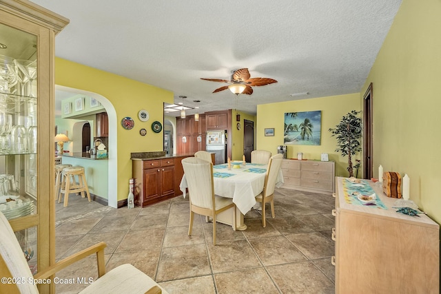 63 Yacht Haven Dr, Cocoa Beach, FL 32931 - dining room with a textured ceiling, a ceiling fan, and arched walkways