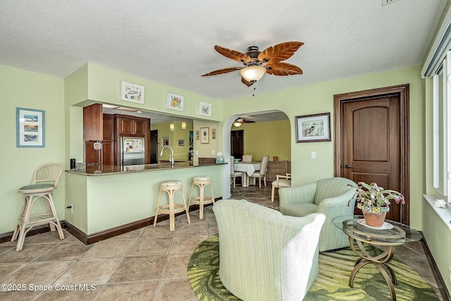 63 Yacht Haven Dr, Cocoa Beach, FL 32931 - living room featuring arched walkways, ceiling fan, and a textured ceiling