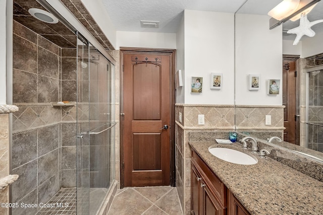 63 Yacht Haven Dr, Cocoa Beach, FL 32931 - bathroom with tile walls, a shower stall, vanity, and tile patterned floors
