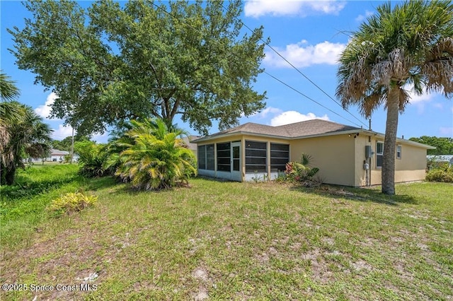 1020 Seamist Ln, Sebastian, FL 32958 - rear view of house with stucco siding, a sunroom, and a lawn