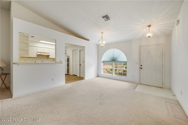 1020 Seamist Ln, Sebastian, FL 32958 - unfurnished living room with a chandelier, carpet flooring, a textured ceiling, and lofted ceiling