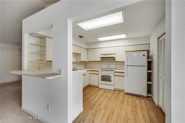 1020 Seamist Ln, Sebastian, FL 32958 - kitchen with white appliances, under cabinet range hood, tasteful backsplash, light countertops, and light wood-type flooring