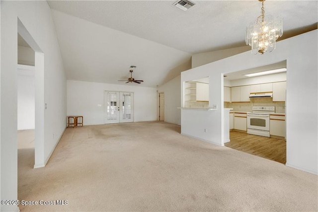 1020 Seamist Ln, Sebastian, FL 32958 - unfurnished living room with light carpet, vaulted ceiling, french doors, a chandelier, and a ceiling fan