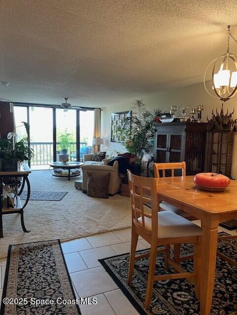 300 Columbia Dr Unit 206-1, Cape Canaveral, FL 32920 - dining area featuring a textured ceiling, a chandelier, and light tile patterned flooring