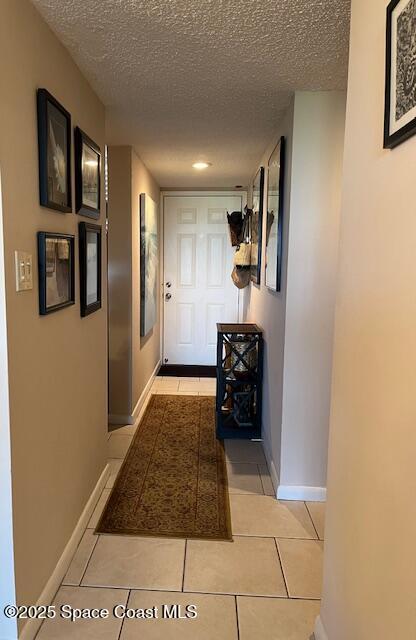 300 Columbia Dr Unit 206-1, Cape Canaveral, FL 32920 - hallway with a textured ceiling and tile patterned flooring