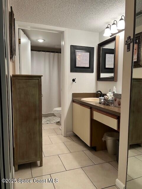 300 Columbia Dr Unit 206-1, Cape Canaveral, FL 32920 - full bathroom with vanity, a textured ceiling, tile patterned floors, and a shower with curtain