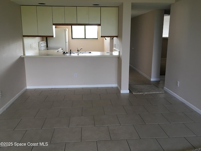 300 Columbia Dr Unit 206-1, Cape Canaveral, FL 32920 - kitchen with electric stove, freestanding refrigerator, light countertops, and a peninsula