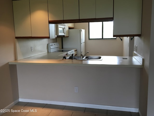 300 Columbia Dr Unit 206-1, Cape Canaveral, FL 32920 - kitchen with white appliances, a peninsula, light countertops, and plenty of natural light