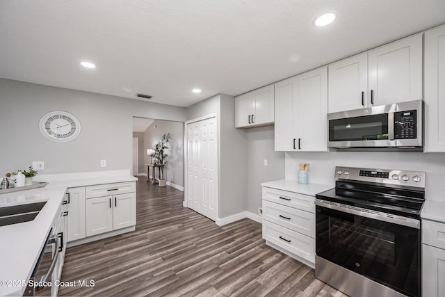 127 Friar Ct, Sebastian, FL 32958 - kitchen featuring stainless steel appliances, light countertops, dark wood-style flooring, and recessed lighting