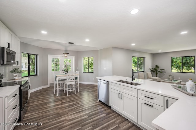 127 Friar Ct, Sebastian, FL 32958 - kitchen featuring stainless steel appliances, light countertops, recessed lighting, dark wood-style floors, and plenty of natural light