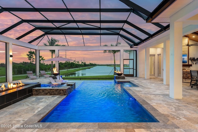 3778 Lake Adelaide Pl, Rockledge, FL 32955 - pool at dusk featuring an outdoor fire pit, a water view, a patio, and an outdoor pool