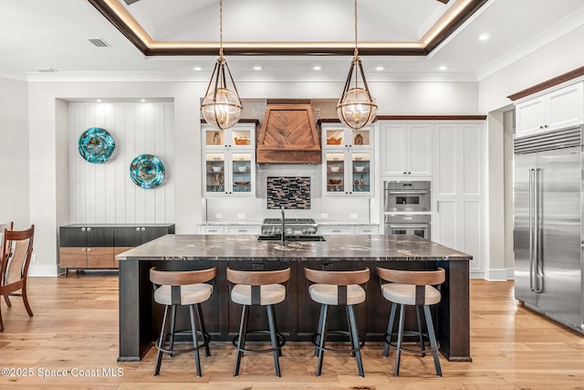 3778 Lake Adelaide Pl, Rockledge, FL 32955 - kitchen featuring stainless steel appliances, custom exhaust hood, ornamental molding, a spacious island, and light wood-style floors