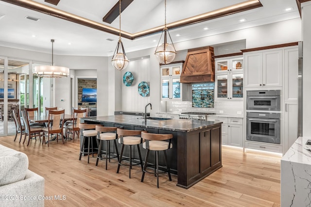 3778 Lake Adelaide Pl, Rockledge, FL 32955 - kitchen featuring double oven, a kitchen bar, decorative backsplash, dark stone counters, and light wood-type flooring