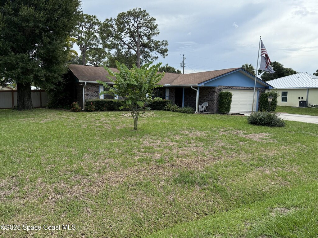 3145 1st Ln, Vero Beach, FL 32968 - ranch-style house featuring a garage, concrete driveway, a front yard, and brick siding