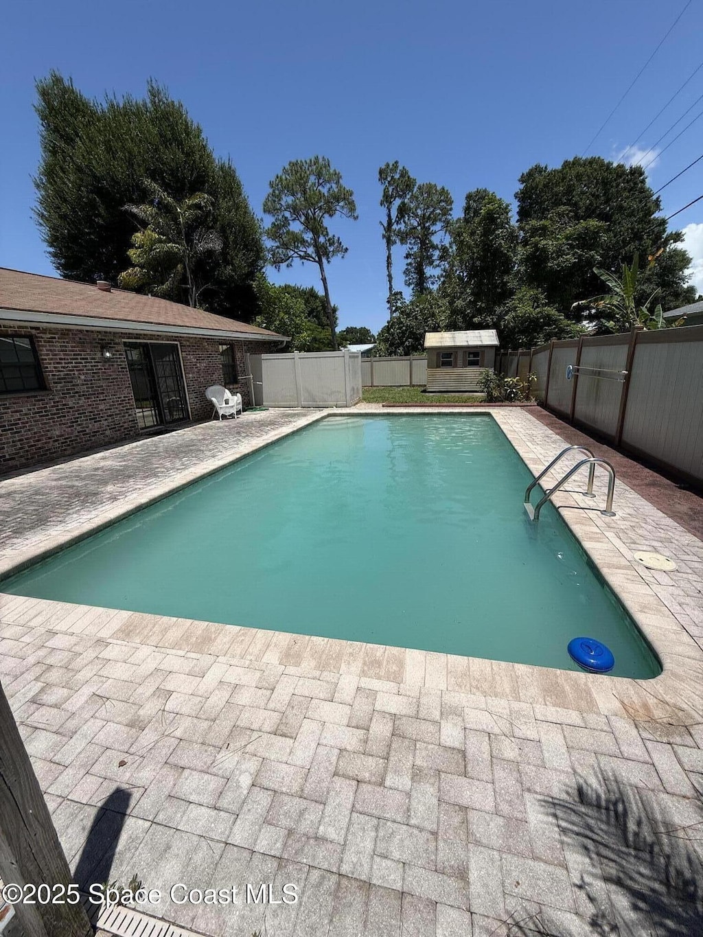 3145 1st Ln, Vero Beach, FL 32968 - view of swimming pool featuring a fenced backyard, a patio, and a storage unit