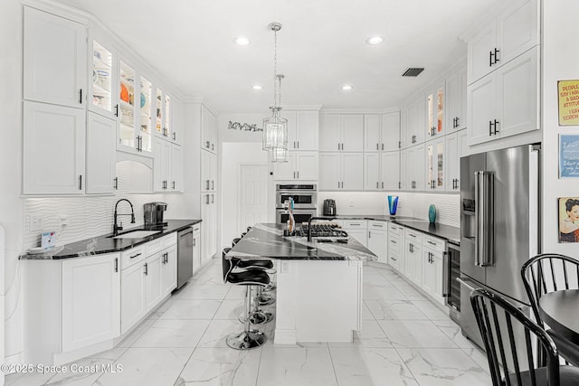 227 Loggerhead Dr, Melbourne Beach, FL 32951 - kitchen with light marble finish flooring, recessed lighting, appliances with stainless steel finishes, white cabinetry, and tasteful backsplash