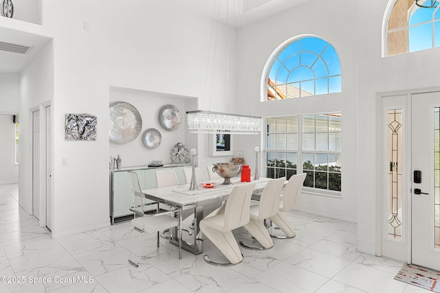 227 Loggerhead Dr, Melbourne Beach, FL 32951 - dining room featuring marble look tiles and a high ceiling