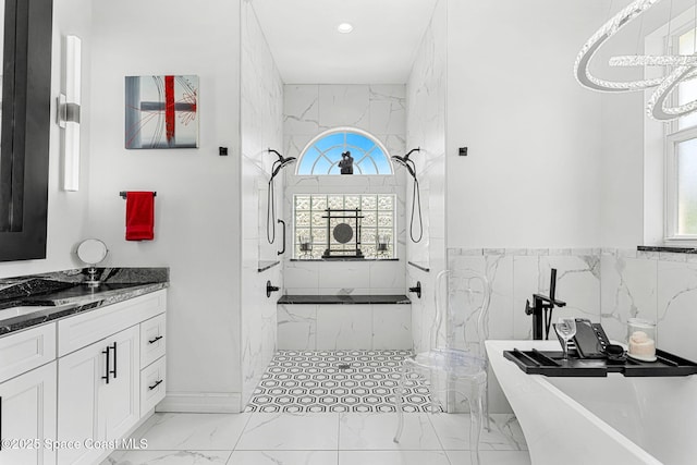 227 Loggerhead Dr, Melbourne Beach, FL 32951 - bathroom with marble finish flooring, healthy amount of natural light, a marble finish shower, a soaking tub, and tile walls