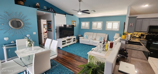 688 Naples Ct, West Melbourne, FL 32904 - living room with a barn door, a ceiling fan, dark wood-type flooring, and vaulted ceiling