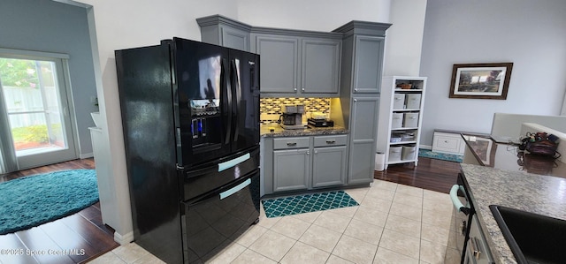 688 Naples Ct, West Melbourne, FL 32904 - kitchen featuring black fridge with ice dispenser, gray cabinets, decorative backsplash, and light tile patterned floors