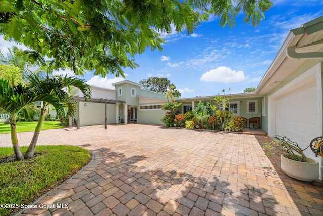 1732 Bay Shore Dr, Cocoa Beach, FL 32931 - view of front of house featuring an attached garage, stucco siding, and driveway
