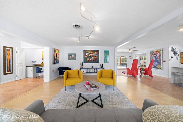 1732 Bay Shore Dr, Cocoa Beach, FL 32931 - living area featuring a desk, wood finished floors, a ceiling fan, and a textured ceiling