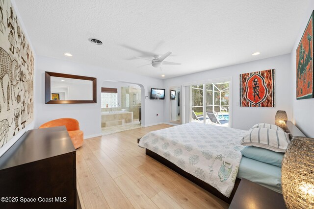 1732 Bay Shore Dr, Cocoa Beach, FL 32931 - bedroom featuring arched walkways, access to exterior, light wood-style flooring, a textured ceiling, and recessed lighting