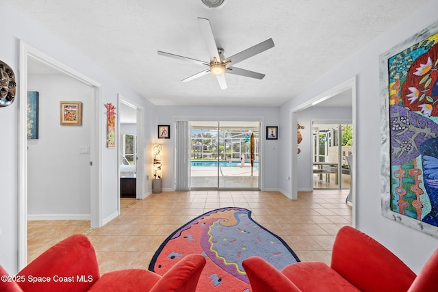 1732 Bay Shore Dr, Cocoa Beach, FL 32931 - living area with a ceiling fan, healthy amount of natural light, tile patterned floors, and a textured ceiling