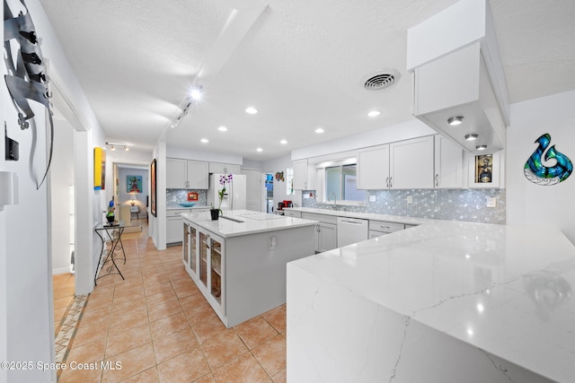 1732 Bay Shore Dr, Cocoa Beach, FL 32931 - kitchen featuring backsplash, white appliances, a center island, light tile patterned floors, and light stone counters