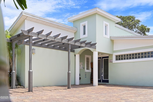 1732 Bay Shore Dr, Cocoa Beach, FL 32931 - view of front of home with stucco siding and a pergola