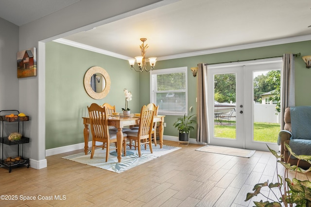 212 Olivick Cir NE, Palm Bay, FL 32907 - dining room with french doors, wood finished floors, a chandelier, and crown molding