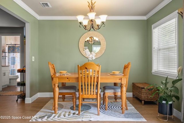 212 Olivick Cir NE, Palm Bay, FL 32907 - dining room with a chandelier, wood finished floors, and ornamental molding