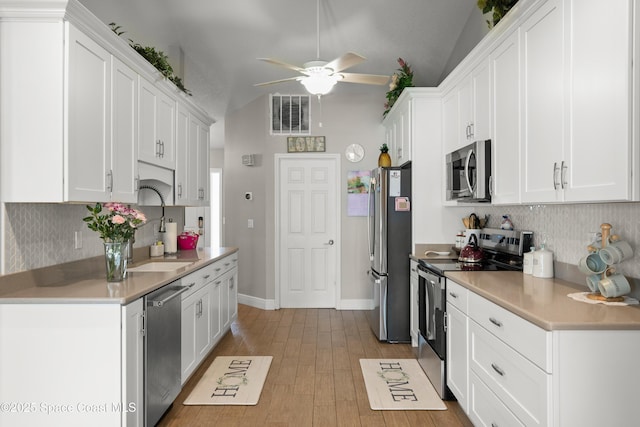 212 Olivick Cir NE, Palm Bay, FL 32907 - kitchen featuring stainless steel appliances, lofted ceiling, decorative backsplash, ceiling fan, and white cabinetry