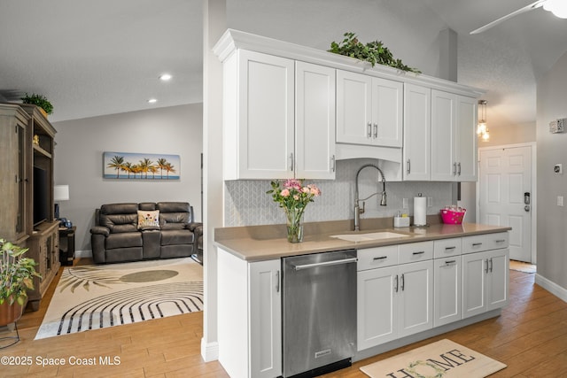 212 Olivick Cir NE, Palm Bay, FL 32907 - kitchen featuring stainless steel dishwasher, light wood-style flooring, tasteful backsplash, light countertops, and white cabinets