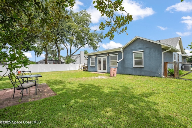 212 Olivick Cir NE, Palm Bay, FL 32907 - back of house with french doors, a fenced backyard, stucco siding, and a patio