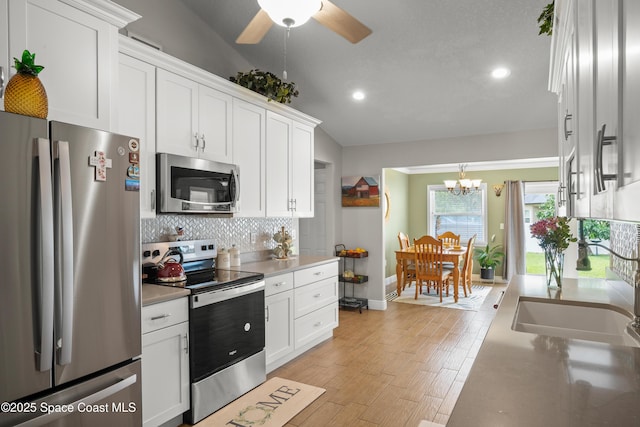 212 Olivick Cir NE, Palm Bay, FL 32907 - kitchen featuring appliances with stainless steel finishes, backsplash, a chandelier, white cabinets, and light countertops