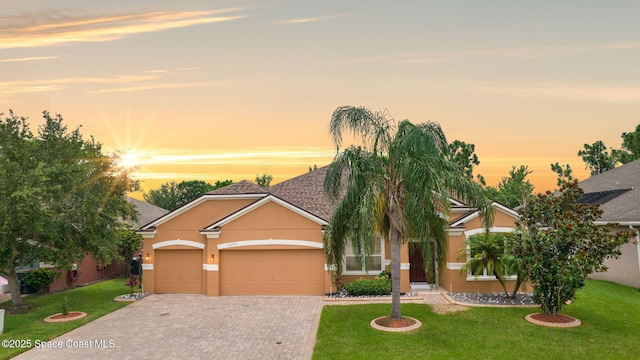 2690 Cypress Tree Trl, Saint Cloud, FL 34772 - view of front of home featuring stucco siding, a front yard, decorative driveway, and a garage