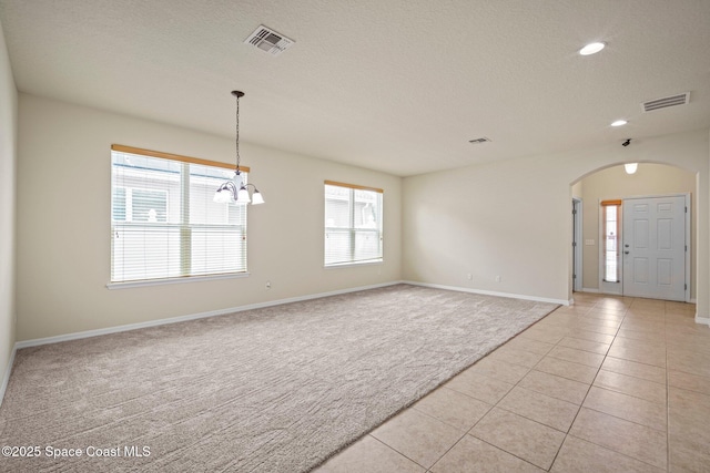 2690 Cypress Tree Trl, Saint Cloud, FL 34772 - unfurnished room with light colored carpet, arched walkways, a chandelier, recessed lighting, and light tile patterned floors