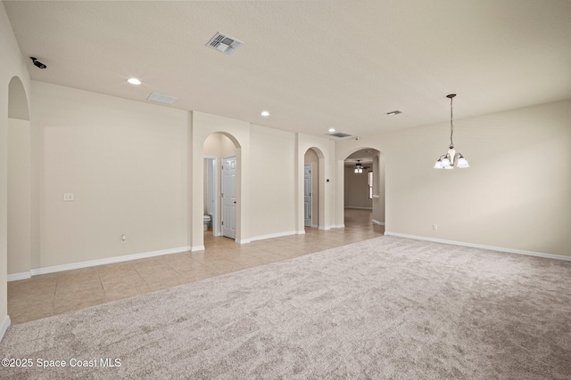 2690 Cypress Tree Trl, Saint Cloud, FL 34772 - spare room featuring a chandelier, arched walkways, light carpet, recessed lighting, and light tile patterned floors