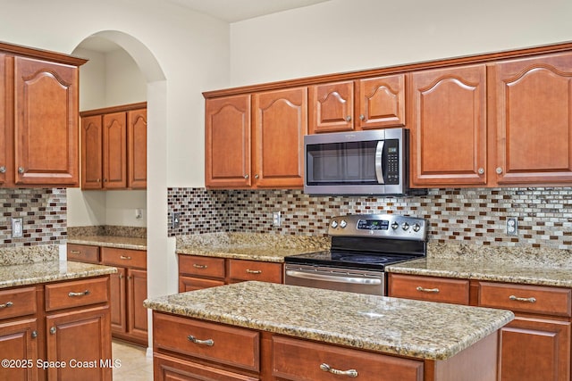 2690 Cypress Tree Trl, Saint Cloud, FL 34772 - kitchen with stainless steel appliances, light stone countertops, and decorative backsplash