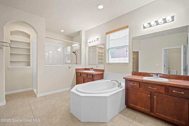 2690 Cypress Tree Trl, Saint Cloud, FL 34772 - bathroom featuring a shower stall, two vanities, a garden tub, and tile patterned flooring
