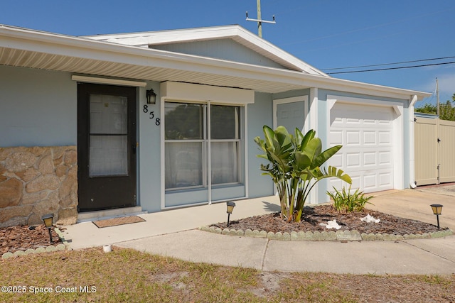 858 Bianca Dr NE, Palm Bay, FL 32905 - entrance to property featuring an attached garage, concrete driveway, and stucco siding