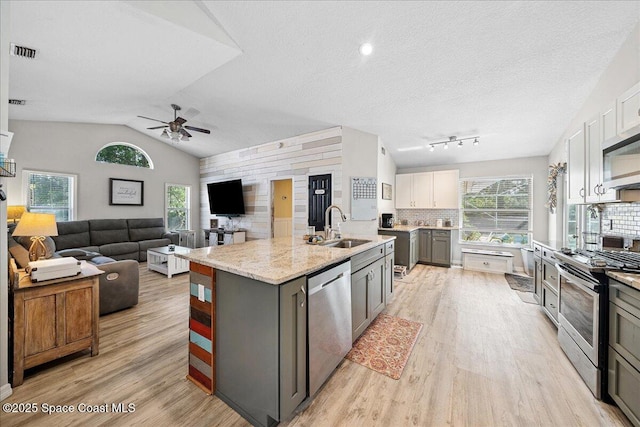 3635 Manassas Ave, Melbourne, FL 32934 - kitchen featuring stainless steel appliances, light wood-type flooring, a center island with sink, gray cabinetry, and ceiling fan