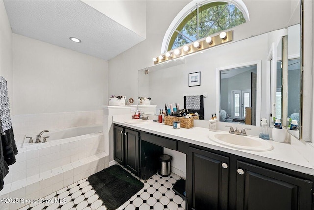 3635 Manassas Ave, Melbourne, FL 32934 - bathroom featuring double vanity, a bath, plenty of natural light, a textured ceiling, and ensuite bath