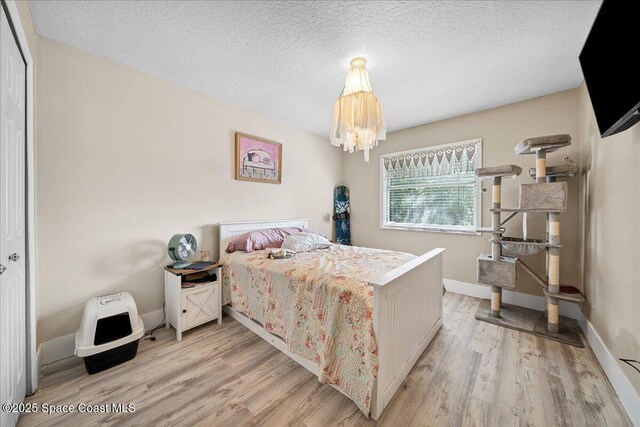 3635 Manassas Ave, Melbourne, FL 32934 - bedroom featuring light wood-style flooring, a chandelier, and a textured ceiling